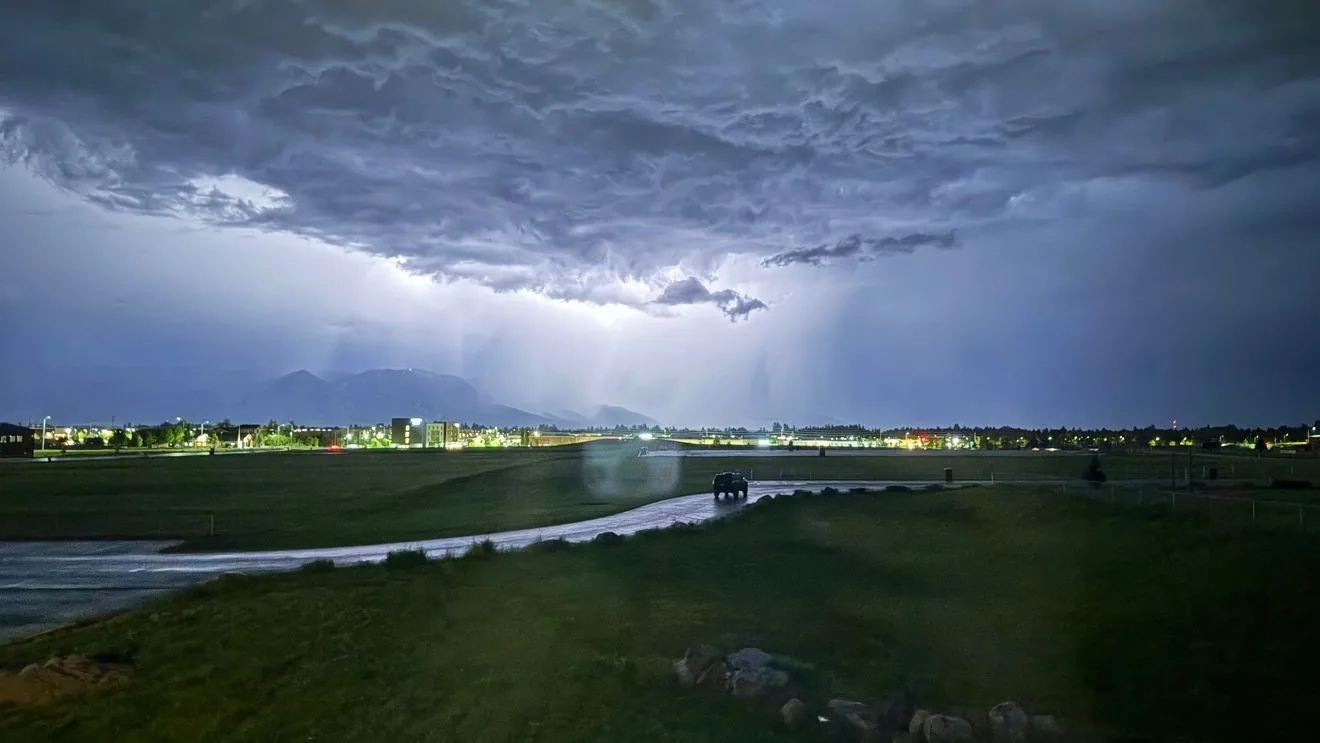Dark thunderstorm clouds building over mountains with a severe weather threat and hot summer conditions